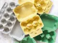 Kolorowe wytłoczki po jajkach leżą obok siebie. Zastanawiasz się, gdzie wyrzucić opakowanie po jajkach? Do pojemnika na papier.