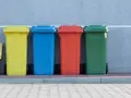 Kolorowe pojemniki na śmieci, w tym żółty, niebieski, czerwony i zielony, stoją obok siebie. Mogą służyć do segregacji odpadów, w tym potencjalnie kod odpadów medycznych igły.