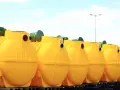 Rząd żółtych, plastikowych zbiorników na szambo ekologiczne. Czy szambo ekologiczne trzeba opróżniać? Tak, nawet te ekologiczne wymagają regularnego serwisu.