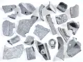 Kawałki metalu, gotowe do recyklingu metalu. Różnorodne kształty i rozmiary, niektóre z otworami, świadczą o ich przemysłowym pochodzeniu.