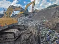 Koparki pracują na wysypisku, zasypując sterty śmieci. To obrazek z życia, gdzie mafia śmieciowa zostawia po sobie ślad.