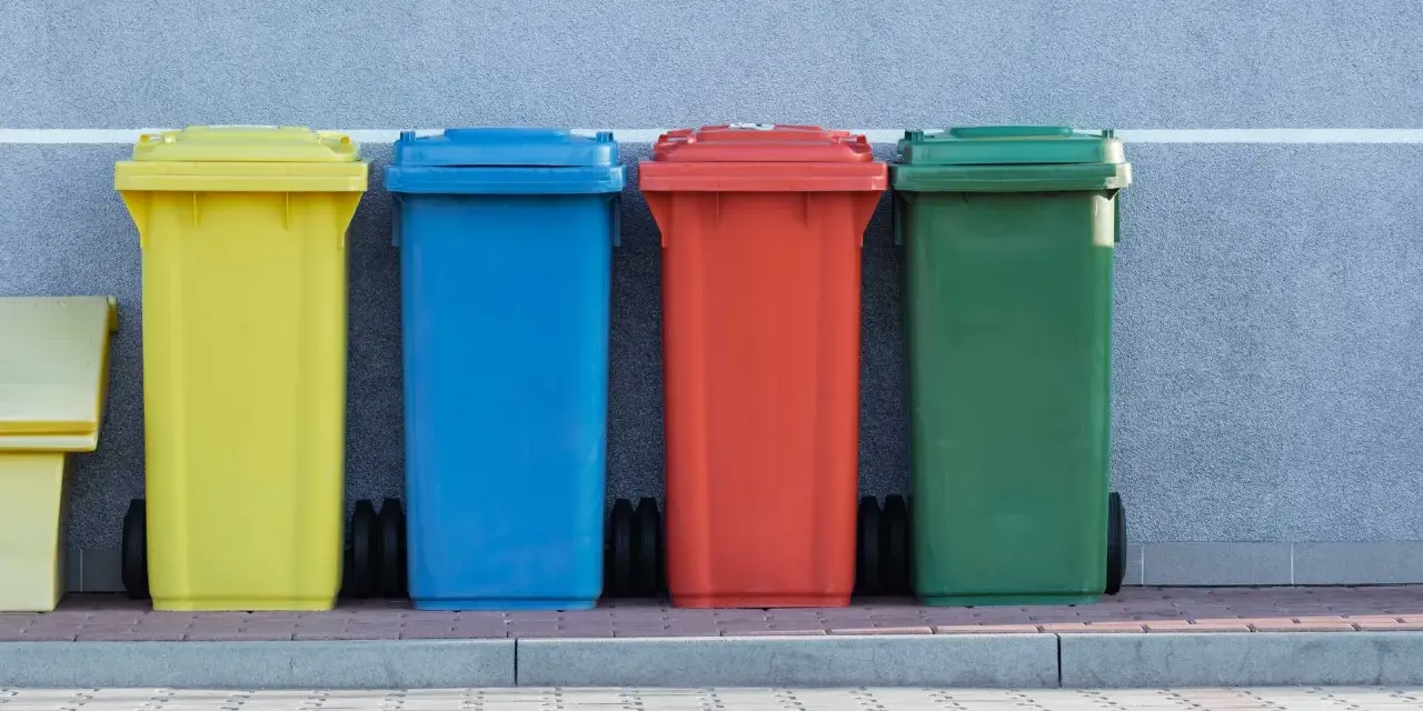 Kolorowe pojemniki na śmieci, w tym żółty, niebieski, czerwony i zielony, stoją obok siebie. Mogą służyć do segregacji odpadów, w tym potencjalnie kod odpadów medycznych igły.