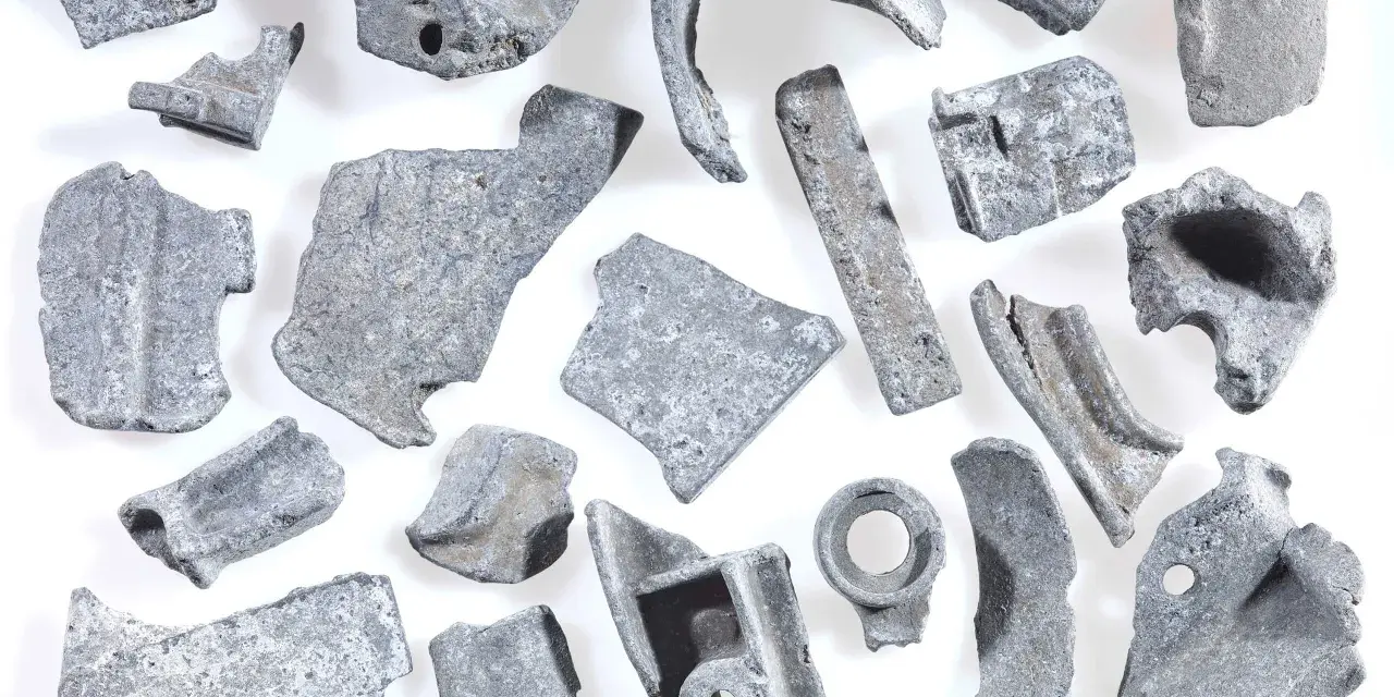 Kawałki metalu, gotowe do recyklingu metalu. Różnorodne kształty i rozmiary, niektóre z otworami, świadczą o ich przemysłowym pochodzeniu.