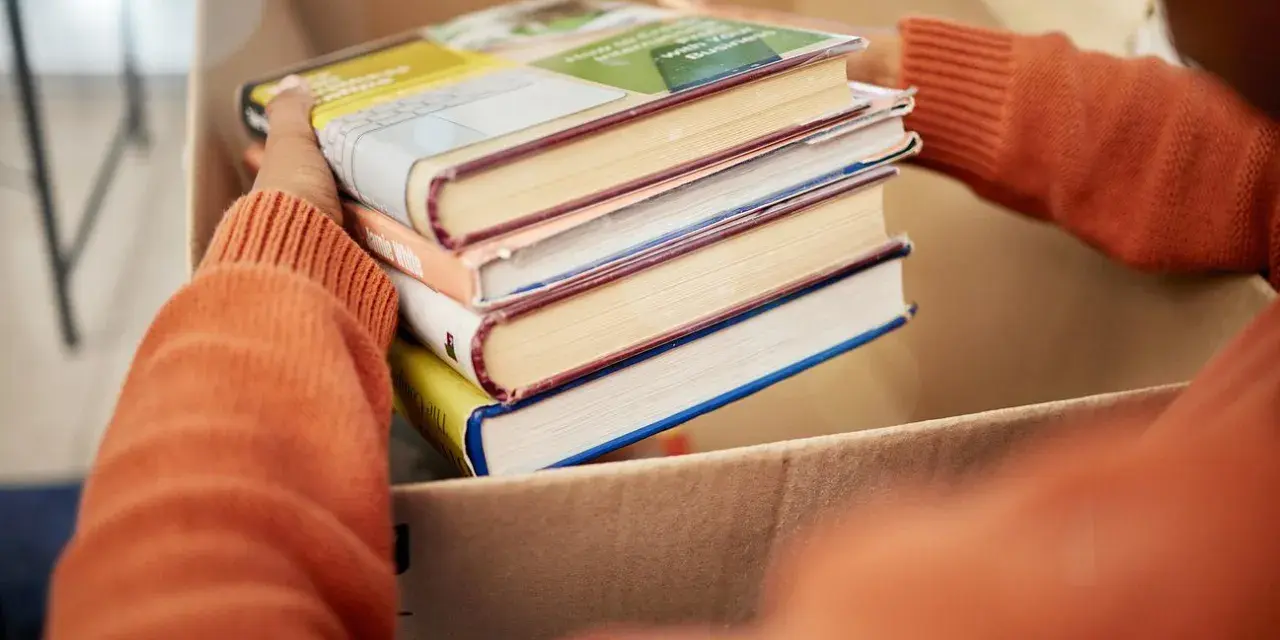 Układanie książek do kartonu, by je oddać. Zastanawiasz się, gdzie oddać książki? Może biblioteka lub punkt zbiórki?