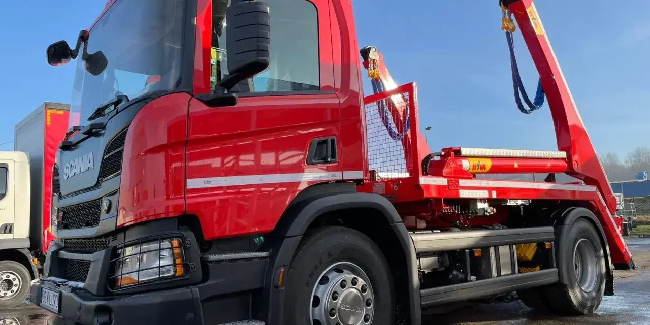 Czerwony hakowiec Scania gotowy do akcji. Sprawdź, jaka jest utylizacja gruzu cena za tonę, by pozbyć się odpadów budowlanych.