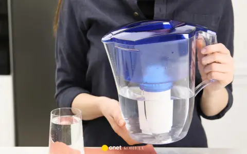 Kobieta trzyma dzbanek z wodą i filtr. Zastanawiasz się, gdzie wyrzucić filtr do wody?