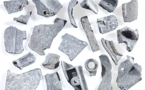 Kawałki metalu, gotowe do recyklingu metalu. Różnorodne kształty i rozmiary, niektóre z otworami, świadczą o ich przemysłowym pochodzeniu.