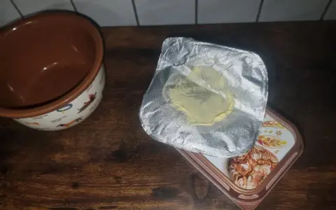 Opakowanie po maśle, które właśnie zostało zużyte, leży obok miseczki z pieskami. Gdzie wyrzucić opakowanie po maśle?
