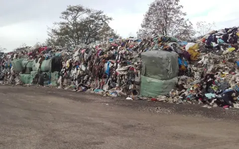 Góra śmieci, głównie ubrań, z zielonymi belami. Zastanawiasz się, ile rozkłada się metal w takim miejscu?
