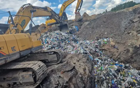 Koparki pracują na wysypisku, zasypując sterty śmieci. To obrazek z życia, gdzie mafia śmieciowa zostawia po sobie ślad.