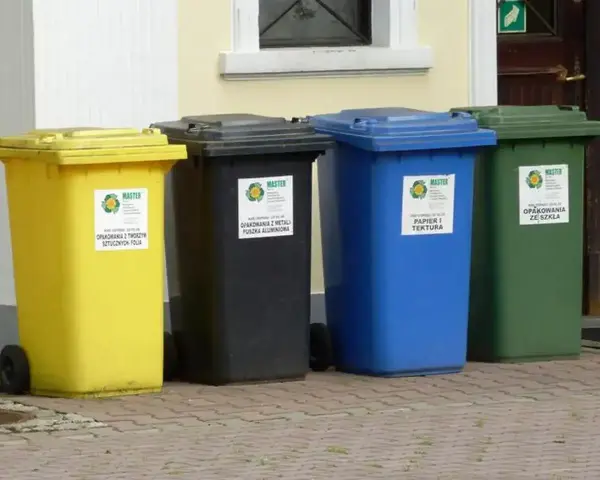 Cztery pojemniki na śmieci: żółty na tworzywa sztuczne, czarny na metale, niebieski na papier i tekstury, zielony na szkło. Gdzie wyrzucić brudny plastik? Do żółtego.