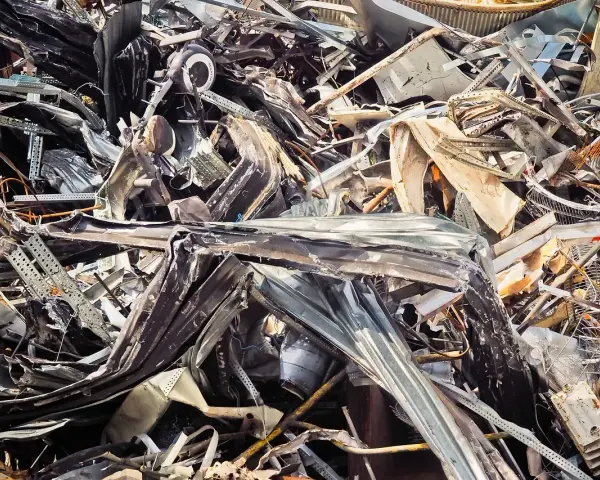Góra złomu, poskręcane metalowe elementy, tworzące chaotyczną strukturę. Widoczne fragmenty blachy, prętów i innych odpadów. Kod odpadu: 17 04 05.