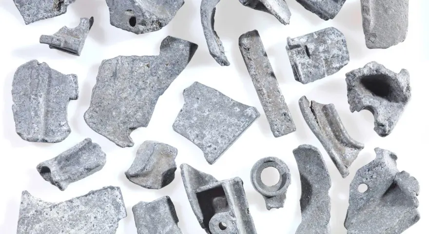 Kawałki metalu, gotowe do recyklingu metalu. Różnorodne kształty i rozmiary, niektóre z otworami, świadczą o ich przemysłowym pochodzeniu.