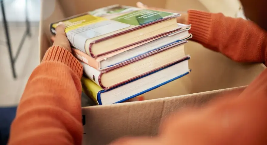 Układanie książek do kartonu, by je oddać. Zastanawiasz się, gdzie oddać książki? Może biblioteka lub punkt zbiórki?