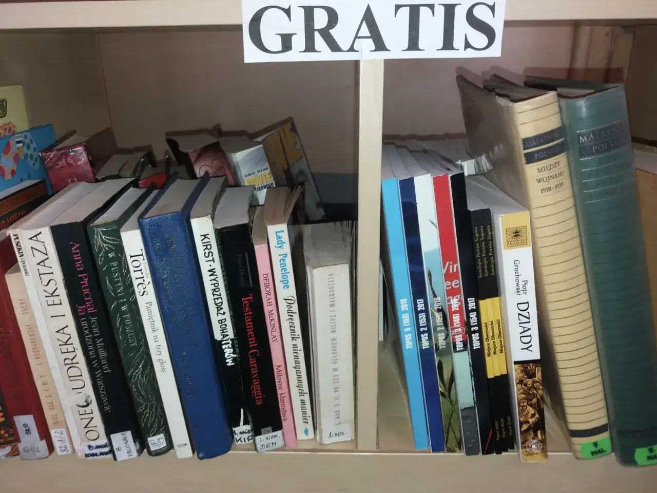 Półka z książkami, na górze napis 