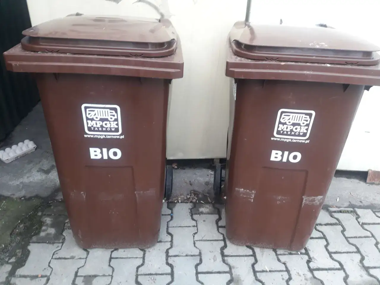 Dwa brązowe kosze na śmieci z napisem 