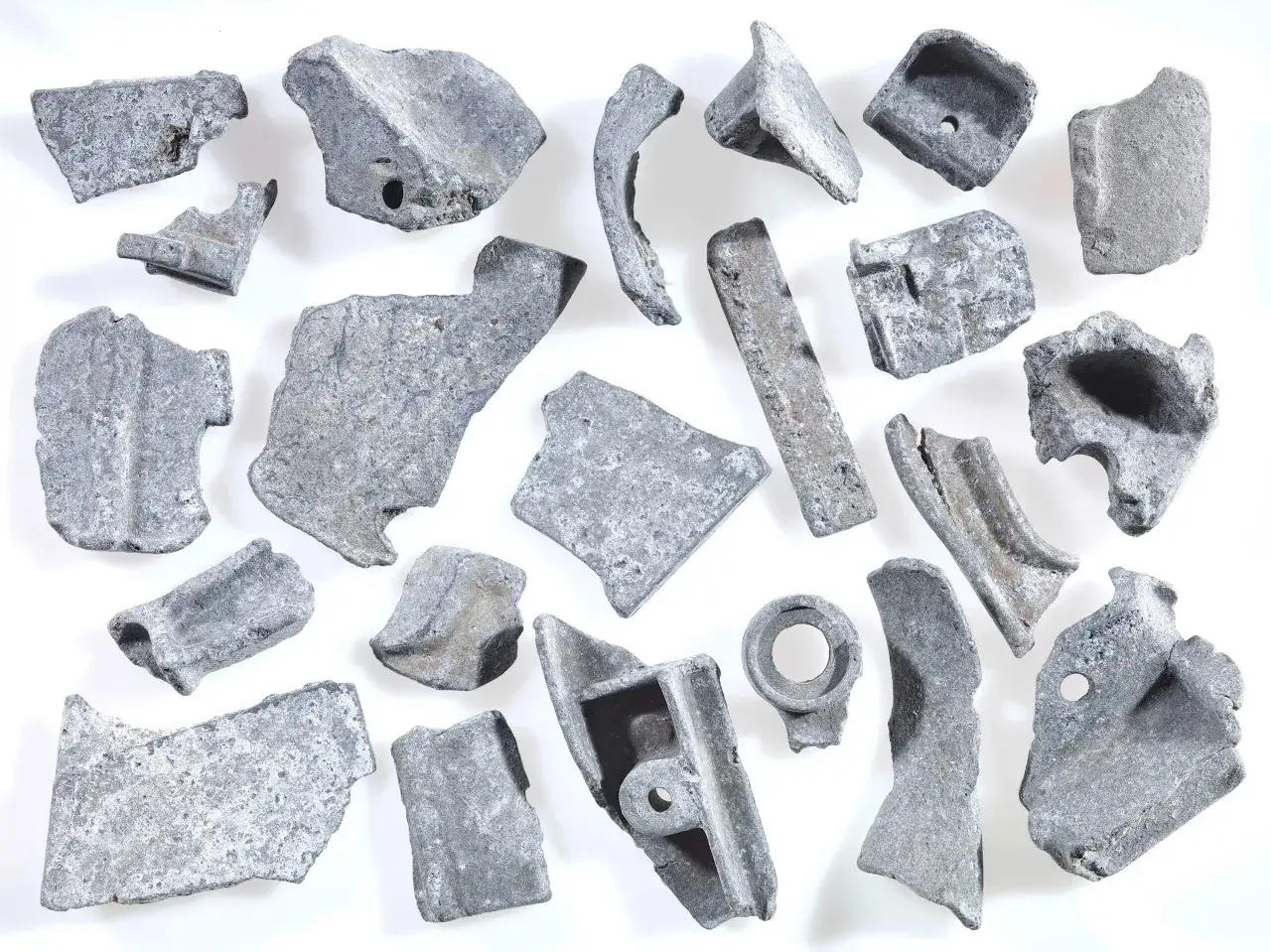 Kawałki metalu, gotowe do recyklingu metalu. Różnorodne kształty i rozmiary, niektóre z otworami, świadczą o ich przemysłowym pochodzeniu.