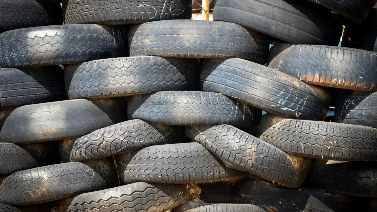 Stos starych opon, które czekają na recykling. Kod odpadu dla opon jest ważny dla prawidłowego zarządzania nimi.
