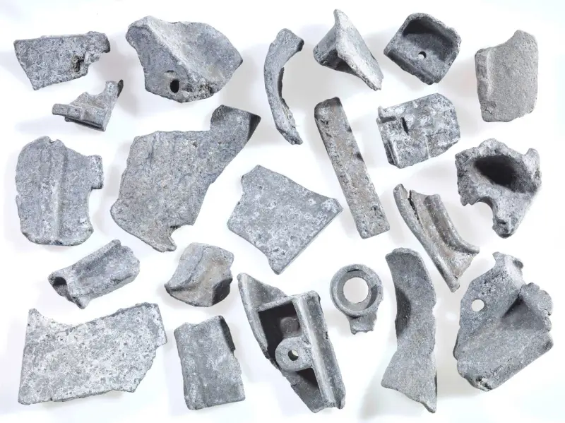 Kawałki metalu, gotowe do recyklingu metalu. Różnorodne kształty i rozmiary, niektóre z otworami, świadczą o ich przemysłowym pochodzeniu.